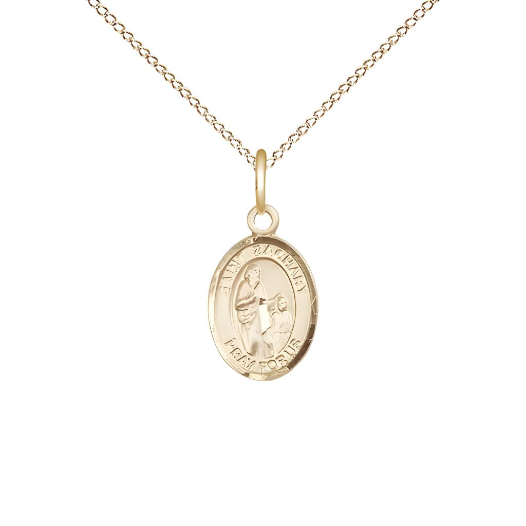 St. Zachary 14kt Gold Oval Small Children Medal with 14kt Gold Chain by Bliss, Measures 1/2-inch tall by 1/4-inch wide.