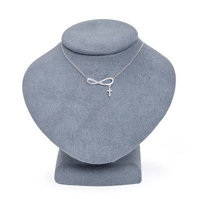 Silver necklace with infinity symbol and cross pendant on a gray jewelry display bust, Singer Company