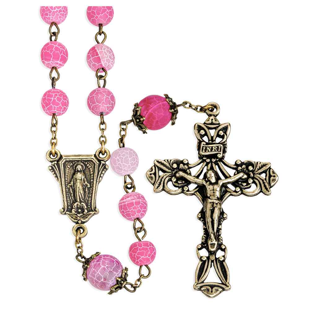 This rosary includes 8mm pink crackled glass beads with antique brass double capped 10mm pink Our Father beads. with brass pierced Miraculous medal centerpiece and a brass pierced crucifix (view 1)