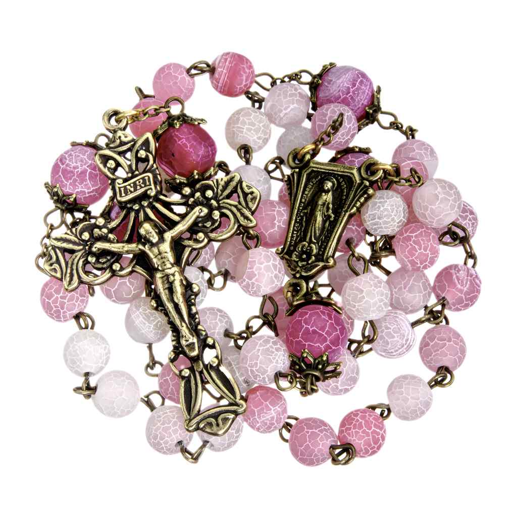 This rosary includes 8mm pink crackled glass beads with antique brass double capped 10mm pink Our Father beads. with brass pierced Miraculous medal centerpiece and a brass pierced crucifix (view 2)